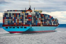 Photo of a large ship carrying shipping containers.