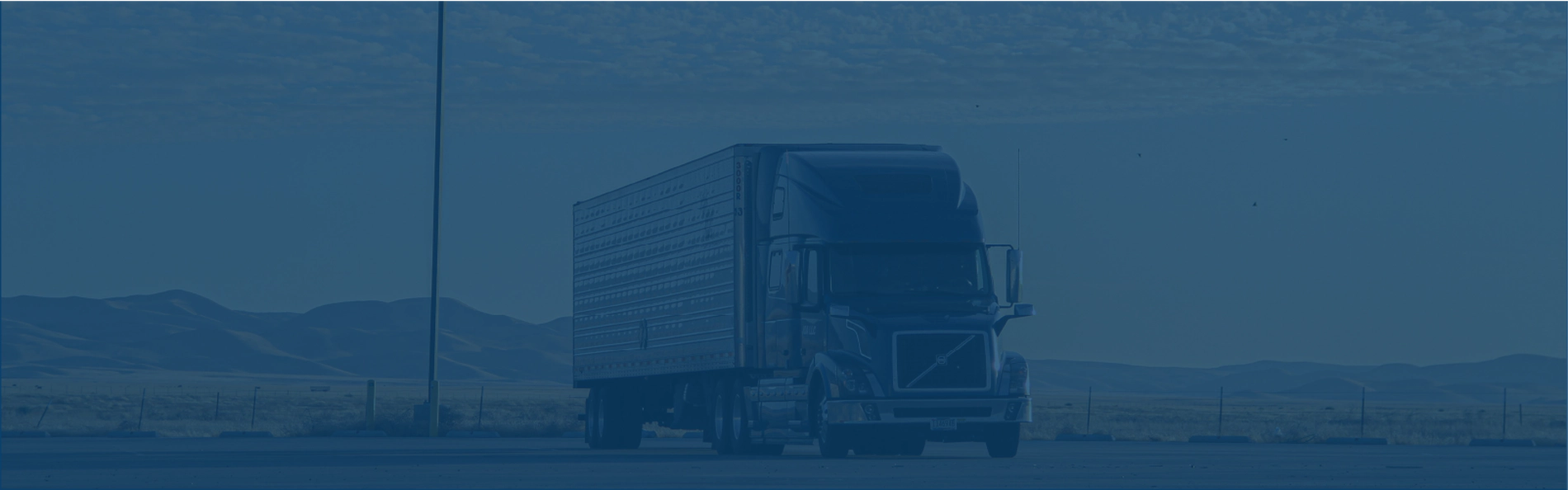 Photo of a truck in a parking lot. Image has a blue overlay.