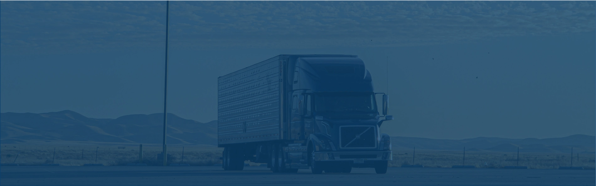 Photo of a truck in a parking lot. Image has a blue overlay. Photo of a truck in a parking lot. Image has a blue overlay.